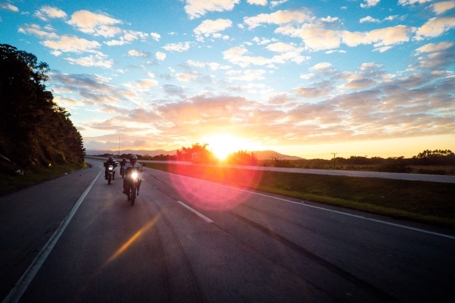 motorcyclists ride at sunset