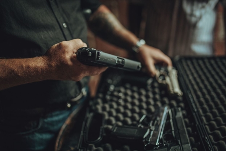 gun shop owner holding a small handgun