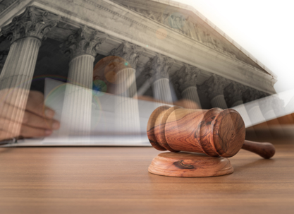 Judges gavel on wooden table with courthouse background